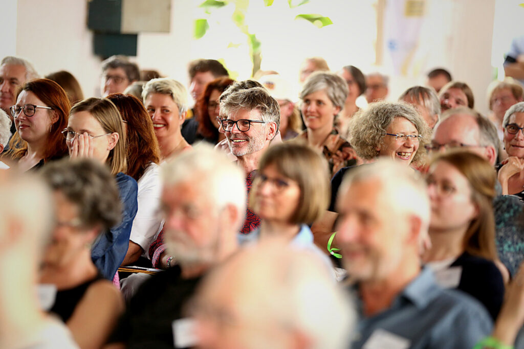 Publikum mit vielen Teilnehmern während einer Firmenveranstaltung – Eventfotografie mit Fokus auf Stimmung