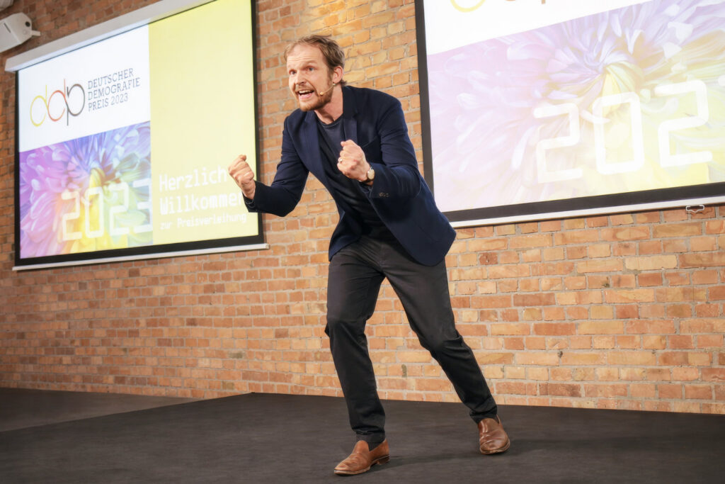 Dynamischer Vortragender vor großer Leinwand bei Firmenevent – Eventfotografie Keynote in Berlin
