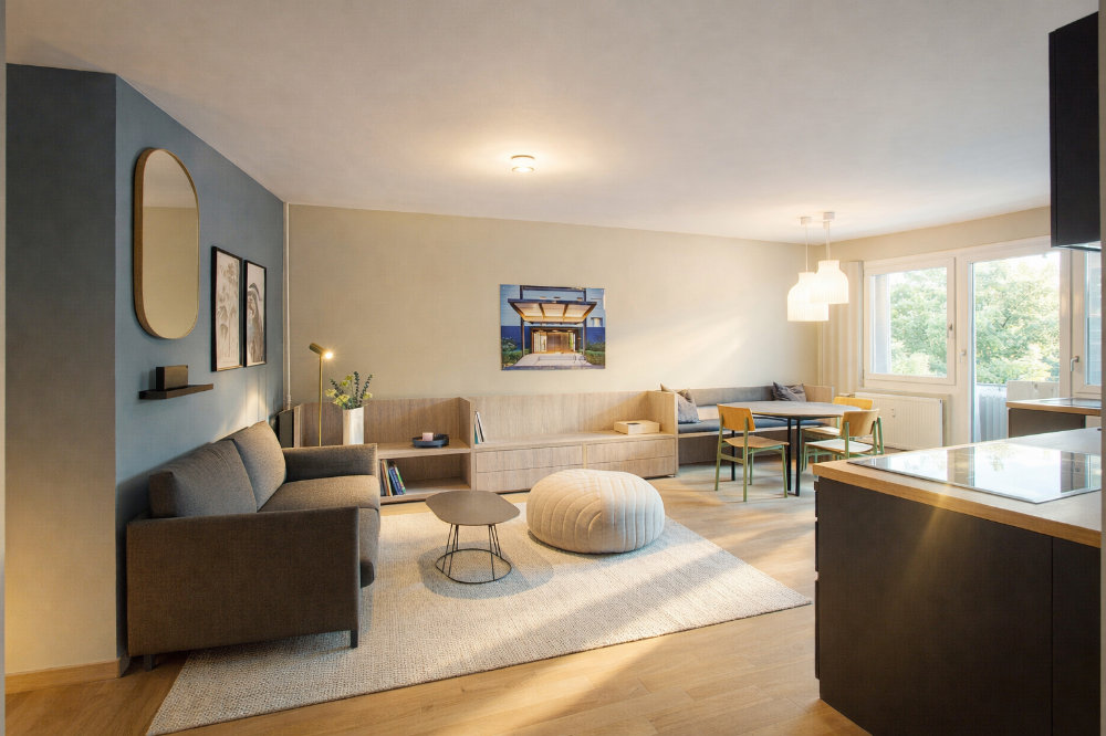 Gemütliches Wohnzimmer mit Design-Sofa, Couchtisch und offener Küche – Innenarchitekturfotografie