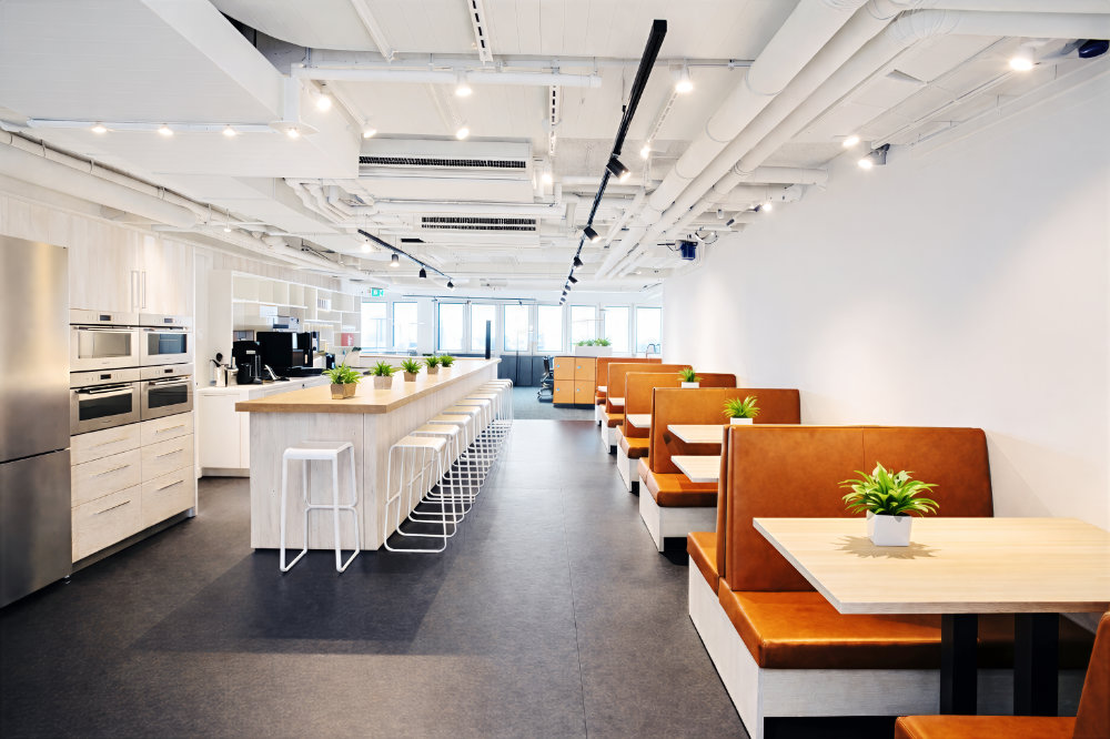 Helle Büroküche mit langer Kücheninsel und Sitznischen – professionelle Innenarchitekturfotografie